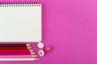 Boş defter ve kalemler ile pembe çalışma masası