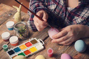 Boya fırçası ve Paskalya yortusu yumurta, rustik ahşap masa DIY kompozisyonu holding Femail eller