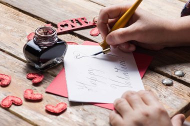 Erkek Happy Valentine işareti, rustik ahşap masa üzerinde DIY kompozisyon yazı el eller. Hat kavramı