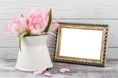 Taze Pembe Lale çiçek sürahi, rustik ahşap arka plan üzerinde boş fotoğraf çerçevesi içinde