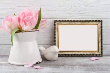 Taze Pembe Lale çiçek sürahi, rustik ahşap arka plan üzerinde boş fotoğraf çerçevesi içinde