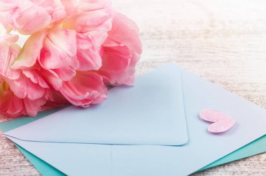 Taze Pembe Lale çiçek, rustik ahşap arka plan üzerinde boş zarflar