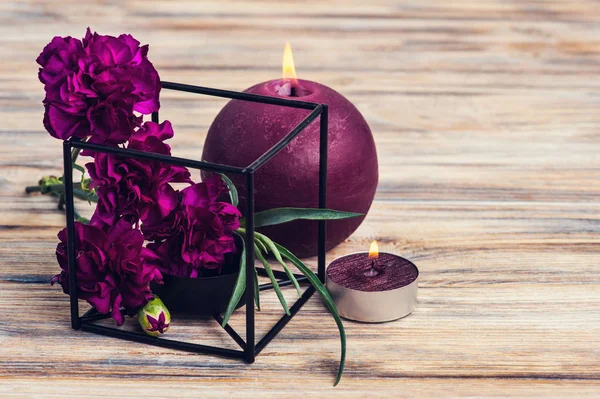 一捆紫色的康乃馨和点燃的蜡烛 — 图库照片