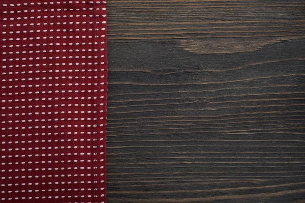 Dunkler Holzhintergrund mit roter Serviette — Stockfoto