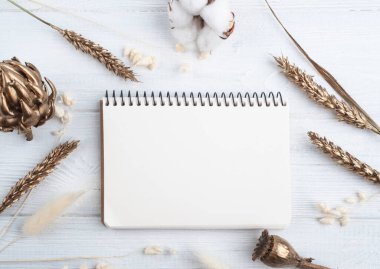 Boş bir defter, altın kuru çiçekler ve dekorasyon için yanan bir mum. Tatil ya da düğün organizatörü konsepti 