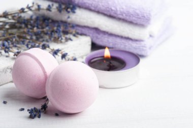 Kuru lavanta çiçekleri ve havlularla kaplıca kompozisyonunda pembe aromalı banyo bombaları. Aromaterapi aranjmanı, yanan mumlarla hayat.