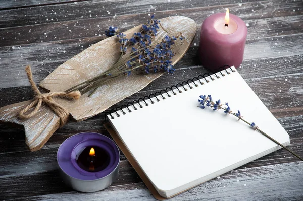 Boş not defteri, mor aroma mumları ve ahşap kırsal arka planda kuru lavanta çiçekleri. Kopya alanı ile yaz veya sonbahar seti