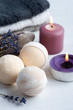 Vanilya aromalı banyo bombaları, kuru lavanta çiçekleri ve havlularla birlikte spa kompozisyonu. Aromaterapi düzenlemesi, yanan mumlarla dolu bir hayat.