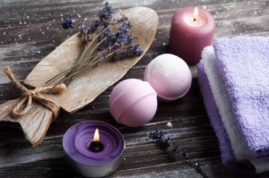 Vanilya aromalı banyo bombaları, kuru lavanta çiçekleri ve havlularla birlikte spa kompozisyonu. Aromaterapi düzenlemesi, yanan mumlarla dolu bir hayat.