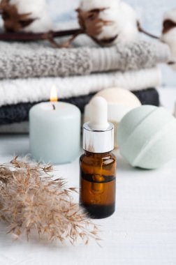 Yağ şişesi ve aromalı banyo bombaları. Kuru çiçekler ve havlularla birlikte spa kompozisyonu. Aromaterapi aranjmanı, yeşil mumlar ve vücut fırçalarıyla dolu bir hayat.