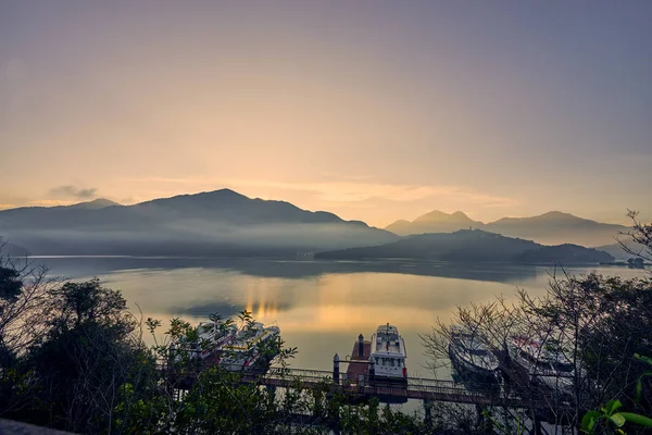 Nantou, Tayvan - 8 Aralık 2018: Sun Moon Gölü'nün çevredeki dağlarıyla birlikte güzel gün doğumu manzaraları, Tayvan'ın Nantou kentinde ki Yuchi'deki bu yayılan gölün en önemli özelliğidir..