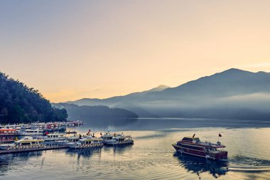Nantou, Tayvan - 8 Aralık 2018: Sun Moon Gölü'nün çevredeki dağlarıyla birlikte güzel gün doğumu manzaraları, Tayvan'ın Nantou kentinde ki Yuchi'deki bu yayılan gölün en önemli özelliğidir..