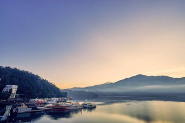 Nantou, Tayvan - 8 Aralık 2018: Sun Moon Gölü'nün çevredeki dağlarıyla birlikte güzel gün doğumu manzaraları, Tayvan'ın Nantou kentinde ki Yuchi'deki bu yayılan gölün en önemli özelliğidir..