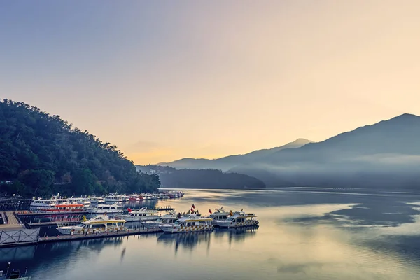 Nantou, Tayvan - 8 Aralık 2018: Sun Moon Gölü'nün çevredeki dağlarıyla birlikte güzel gün doğumu manzaraları, Tayvan'ın Nantou kentinde ki Yuchi'deki bu yayılan gölün en önemli özelliğidir..