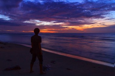 sunrise plajda otururken tanımsız seyahat süresi / yalnız adam