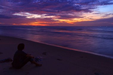 sunrise plajda otururken tanımsız seyahat süresi / yalnız adam