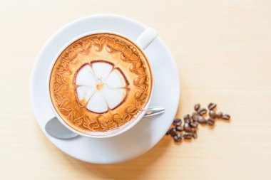 sıcak cappuccino kahve masada sevimli krem desenli / sıcak kahve