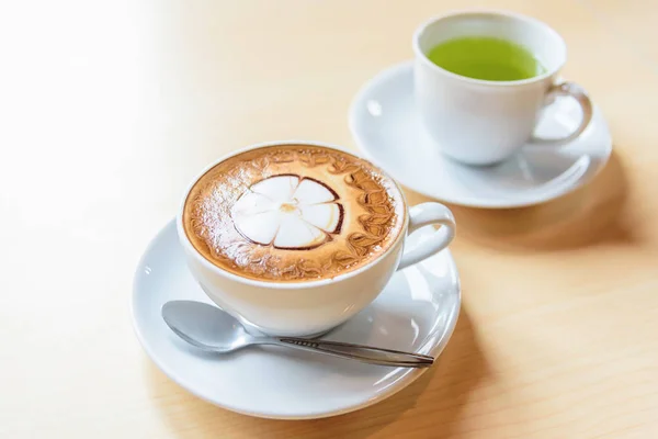 ホット テーブルにかわいいクリーム パターンとカプチーノ コーヒー ホット コーヒー — ストック写真