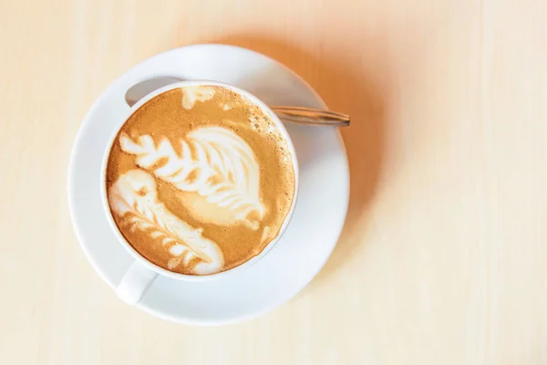热卡布奇诺咖啡与漂亮的图案泡沫在桌子上 热咖啡 — 图库照片