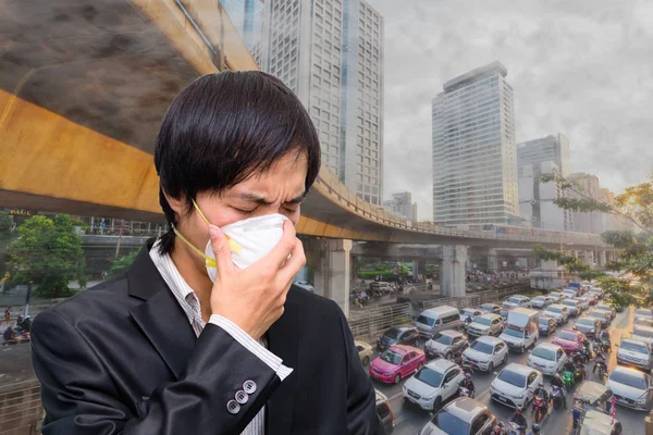 A business man wear Hygienic mask and city pollution on background / Wear Hygienic mask for protect PM2.5 Dust