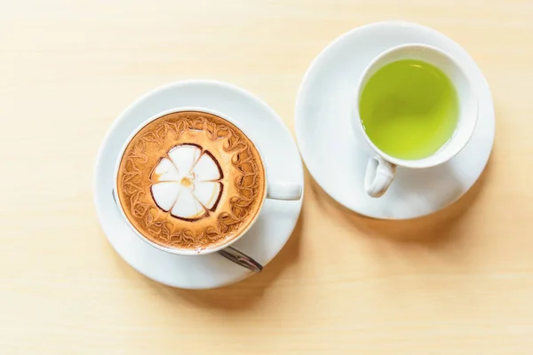 hot cappuccino coffee with green tea on table