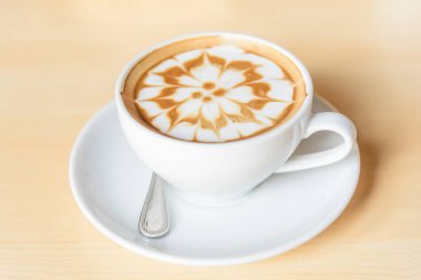 Sıcak kapuçino. Masanın üzerinde köpük desenli güzel bir kahve.