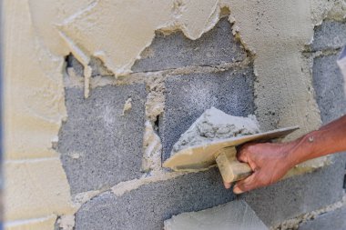 İşçi sıva inşaat alanında çimento duvarı