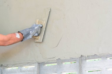 İşçi sıva inşaat alanında çimento duvarı