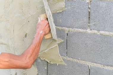 İşçi sıva inşaat alanında çimento duvarı