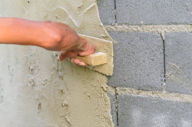 İşçi sıva inşaat alanında çimento duvarı