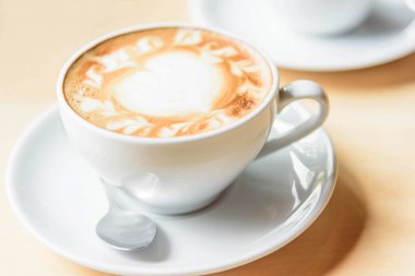 Sıcak kahve, sıcak kapuçino ve güzel desenli süt köpüğü. 