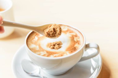 İçecek için sıcak kahveye şeker ekleyin