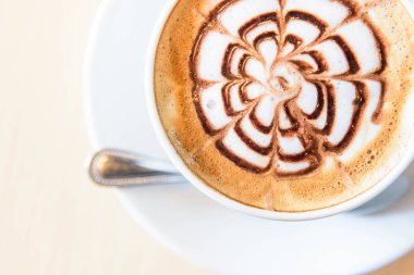 Sıcak kahve, sıcak kapuçino ve güzel desenli süt köpüğü. 