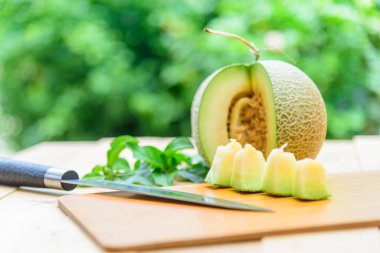 Portakal karpuzunu ahşap tabakta ikiye ayır.