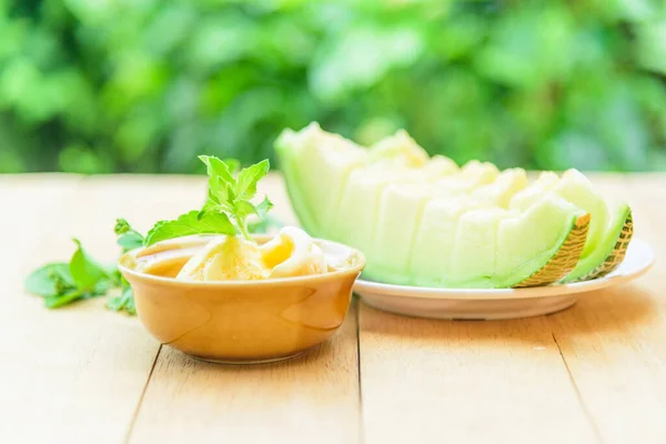 ice cream melon with green melon for eating on wood table