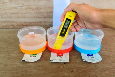 Ph sayacını test etmeden önce kalibre eden adam.