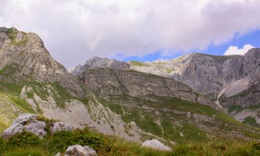 Karadağ ulusal parkında Durmitor Ring karayolu panoraması. Yüksek dağların manzarası, yeşil alp bitkisi ve kıvrımlı yol
