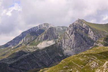 Karadağ ulusal parkında Durmitor Ring karayolu panoraması. Yüksek dağ zirveleri, yeşil alp bitkileri ve kıvrımlı yol manzarası