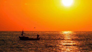 Akdeniz 'de gün batımından önce Alanya Türkiye' de teknede balıkçı