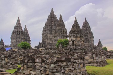 Taş, ünlü Prambanan Hindu tapınağı Yogyakarta, Java, Endonezya 'da duruyor. Candi Prambanan bir taraftan görüldü. Taştan yapılar ve molozlar ikonik seyahat noktasında.