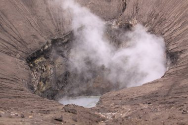 Bromo Dağı, güneş doğmadan önce ana kraterden çıkan duman, Java Endonezya. Bromo Tengger Semeru Ulusal Parkı. Etkin yanardağın dumanı altında