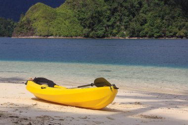 Sarı kano kumsalda, egzotik tropikal seyahat noktalarının sahillerinde Pasumpahan Adası, Padang, Batı Sumatra, Endonezya
