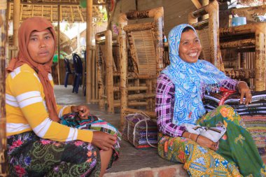 Lombok 'ta batik satan köyden Sasak bir kadın. Kuta Lombok Endonezya adasında egzotik bir cennettir. Güzel beyaz kumlu plajları ve kristal berrak turkuaz suları vardır..