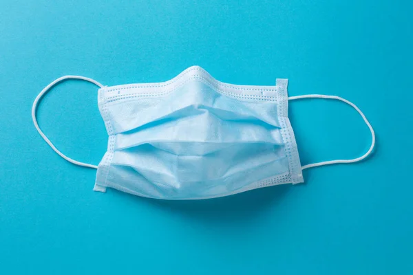 mavi arka planda izole edilmiş bir cerrahi maske
