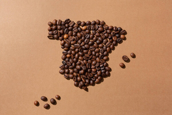 Map of Spain made with coffee beans on brown background