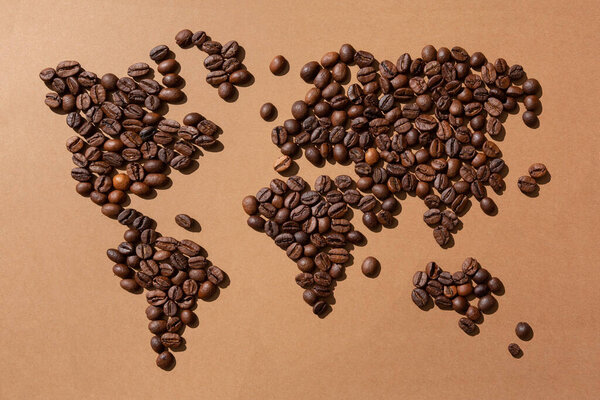World map made with coffee beans on brown background
