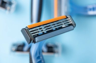 Kapalı çekimli jilet ve alttaki diğer bıçakları mavimsi arkaplanda detaylandır