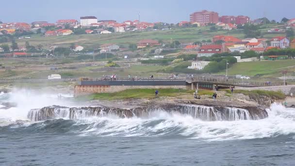 海浪冲击着海岸的石头 人们在观看 — 图库视频影像