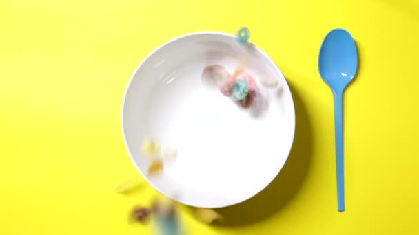 Cereals Various Colors Shapes Falling Breakfast Cup Seen Yellow Background — Stock Video