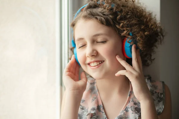 Kulaklıklı kız. İzolasyon sırasında ev müziği. Bir genç pencereye oturur ve müzik dinler. Gözler zevkle kapalı